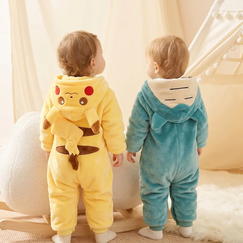 Dois bebês de pé vestindo o macacão do pikachu e snorlax