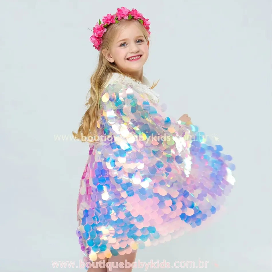 Menina girando com a Capa Infantil Temática Sereia Encantada, mostrando o brilho e fluidez do tecido holográfico.