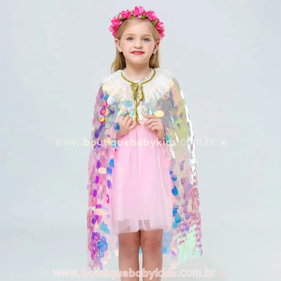 Menina usando a capa infantil sereia em pé, de frente, com seu fecho em fita dourada e gola detalhada.