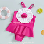 Maiô rosa vibrante com aplicação de flor volumosa na parte frontal, com fundo temático de verão.