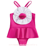 Vista frontal do maiô infantil rosa com saia e flor branca costurada, peça perfeita para looks de verão e praia.