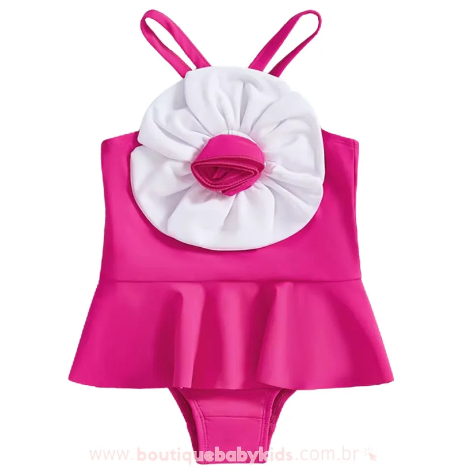Vista frontal do maiô infantil rosa com saia e flor branca costurada, peça perfeita para looks de verão e praia.