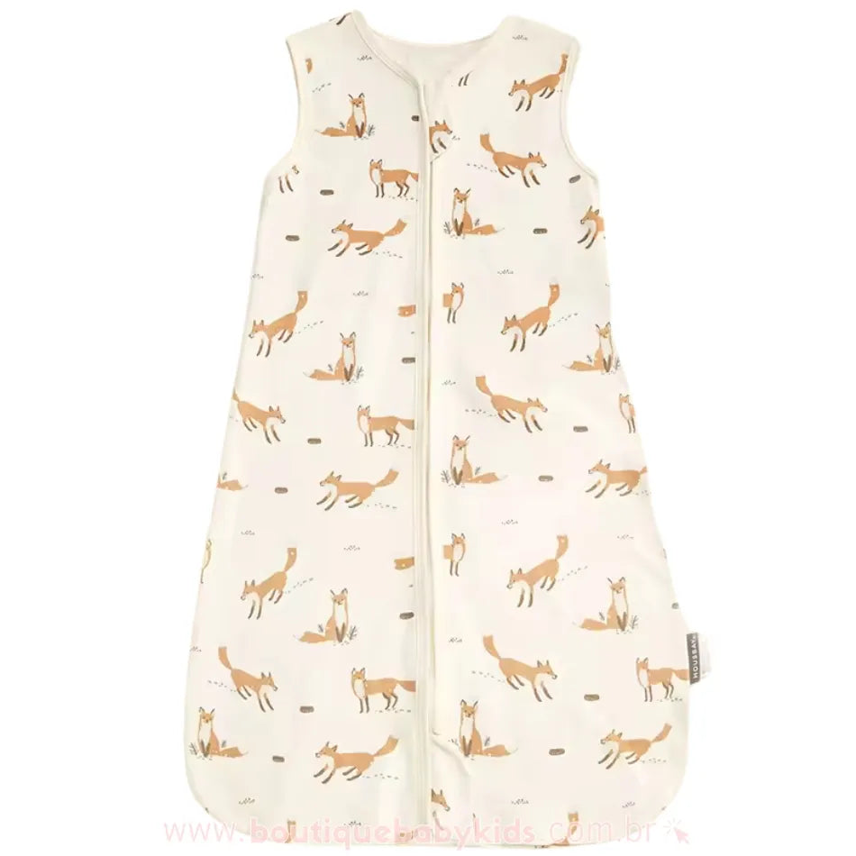 Saco de dormir infantil exposto em fundo branco, destacando sua modelagem ampla, fechamento em zíper frontal e estampa delicada de raposas em tons suaves.