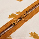 Close-up do zíper duplo do Saco de Dormir Bebê Folhas de Outono, projetado para facilitar a troca de fraldas e proporcionar mais praticidade para os pais.