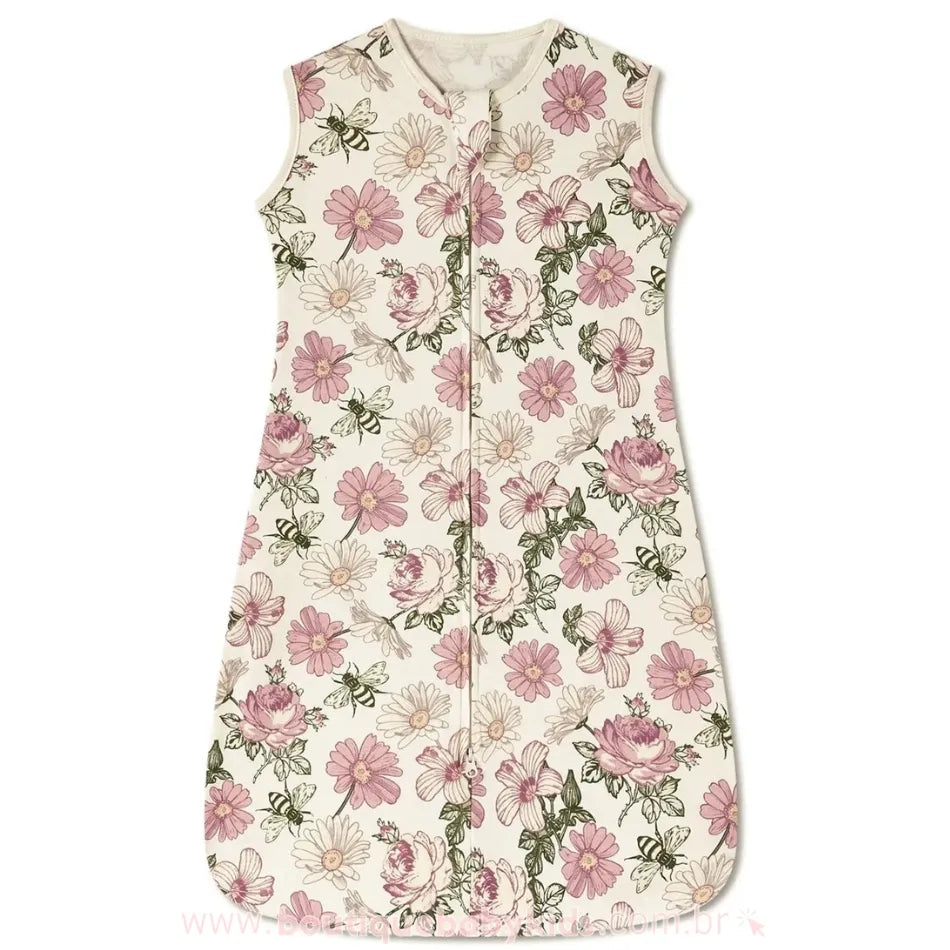 Saco de Dormir Bebê Jardim de Sonhos – saco de dormir infantil sem mangas, com fundo bege e estampa floral delicada em tons de rosa e verde. Possui um zíper frontal com proteção no topo para evitar contato direto com a pele do bebê. O tecido é macio e confortável, ideal para proporcionar noites aconchegantes e seguras.