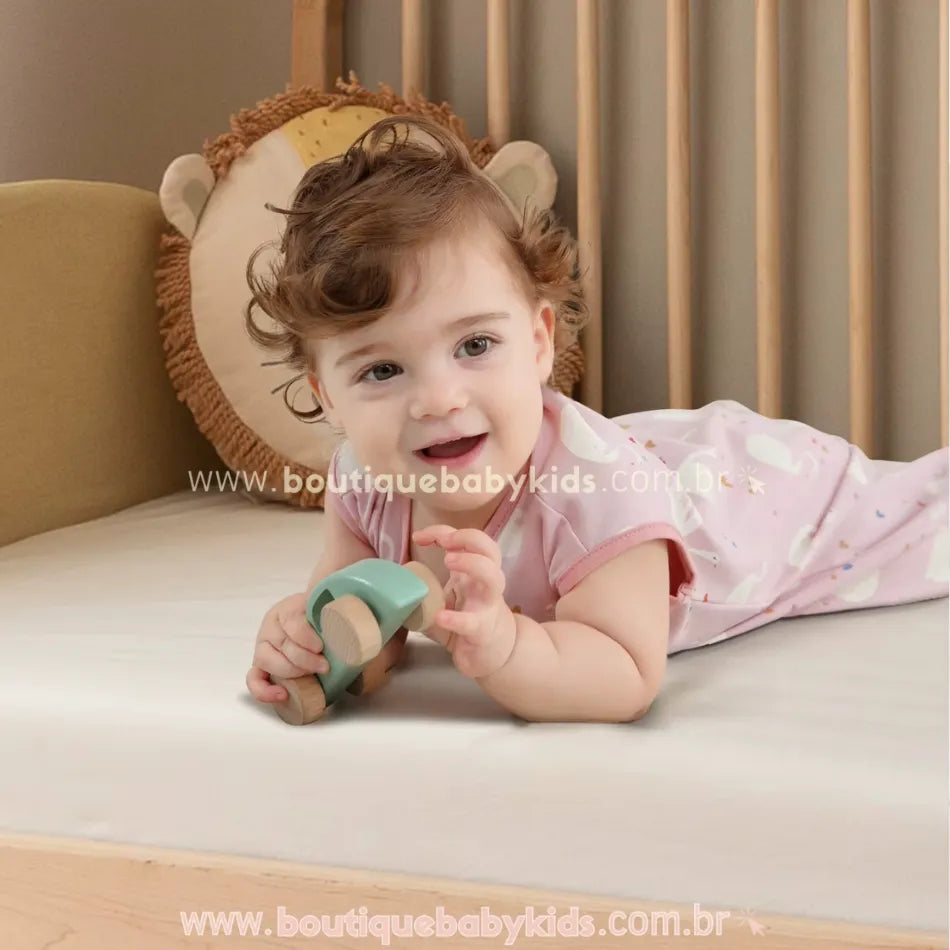 Bebê sorrindo enquanto usa o saco de dormir infantil sem mangas, proporcionando liberdade de movimentos e conforto térmico.