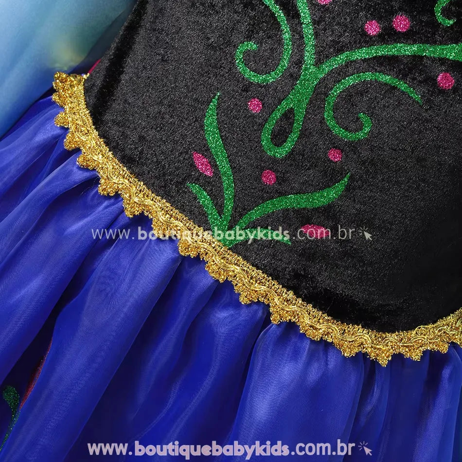 Corpete de veludo preto com detalhes bordados em glitter verde e rosa, finalizado com fita dourada na cintura.