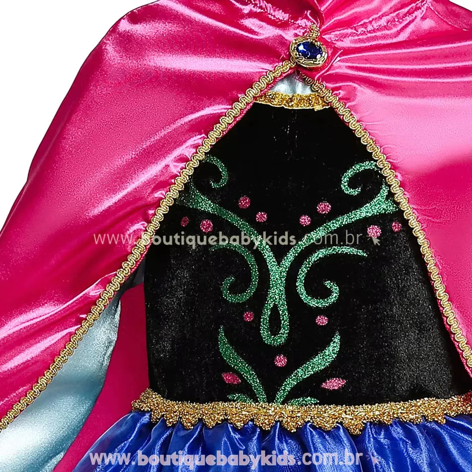 Capa rosa brilhante fixada ao vestido, com bordas douradas e acabamento sofisticado.