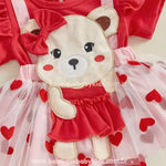 Vestido Bebê Ursinha Apaixonada com Faixa, com aplicação bordada de ursinha fofa, vestidinho vermelho e saia de tule com corações vermelhos. Um look encantador para datas especiais.