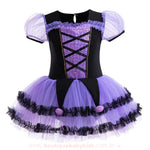 Vestido infantil temático de bruxinha na cor preta e roxa, com mangas bufantes de tule, corpete com detalhe de espartilho e saia volumosa de tule com babadinhos pretos e pompons roxos.