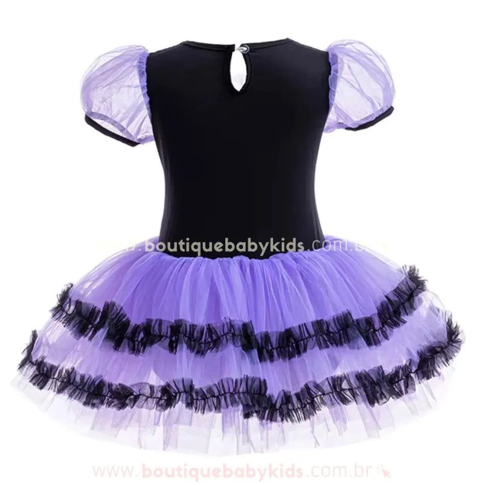  Parte traseira do vestido infantil de bruxinha, com fechamento discreto em botão e mangas bufantes de tule roxo.