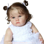 Foto da Boneca Bebê Reborn Camila, destacando os detalhes do vestido branco e os traços realistas do rosto.