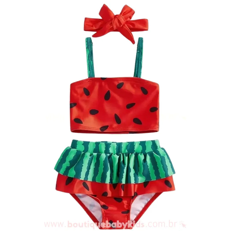 Conjunto Biquíni Bebê Melancia Summer completo em fundo branco. O kit inclui top vermelho com sementes pretas, calcinha com babado verde listrado imitando a casca e uma faixa de cabelo vermelha com laço.