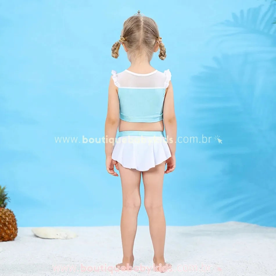 Vista traseira do biquíni infantil Princesa Cinderela, mostrando o top com transparência na parte superior e a saia embutida no shortinho, enquanto a menina está de costas.