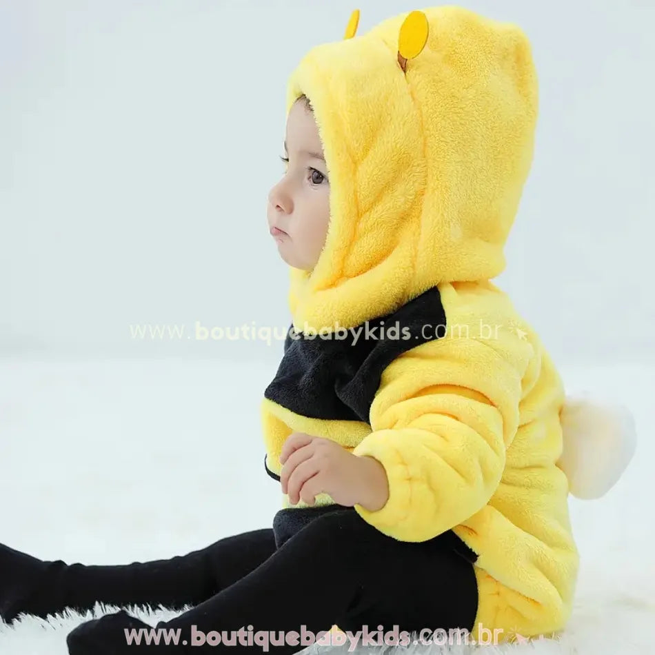 Bebê sentando de lado usando o body de Abelhinha para bebê com capuz peluciado e listras temáticas amarelas e pretas