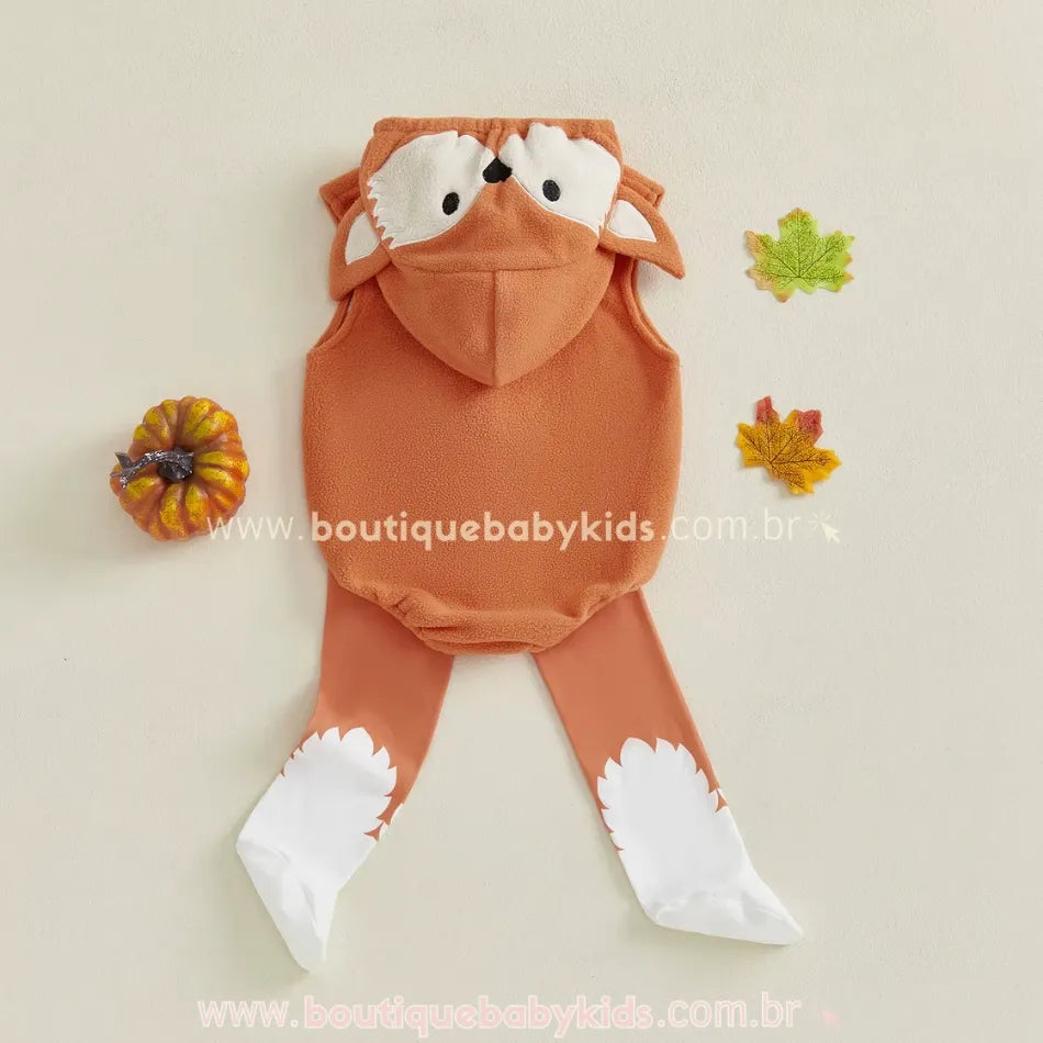 Vista traseira do body bebê raposinha com capuz bordado e meias decorativas em fundo com folhas de outono.