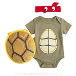 Kit fantasia bebê Tartaruga Ninja completo, composto por body manga curta verde, máscara vermelha e casco de pelúcia removível.