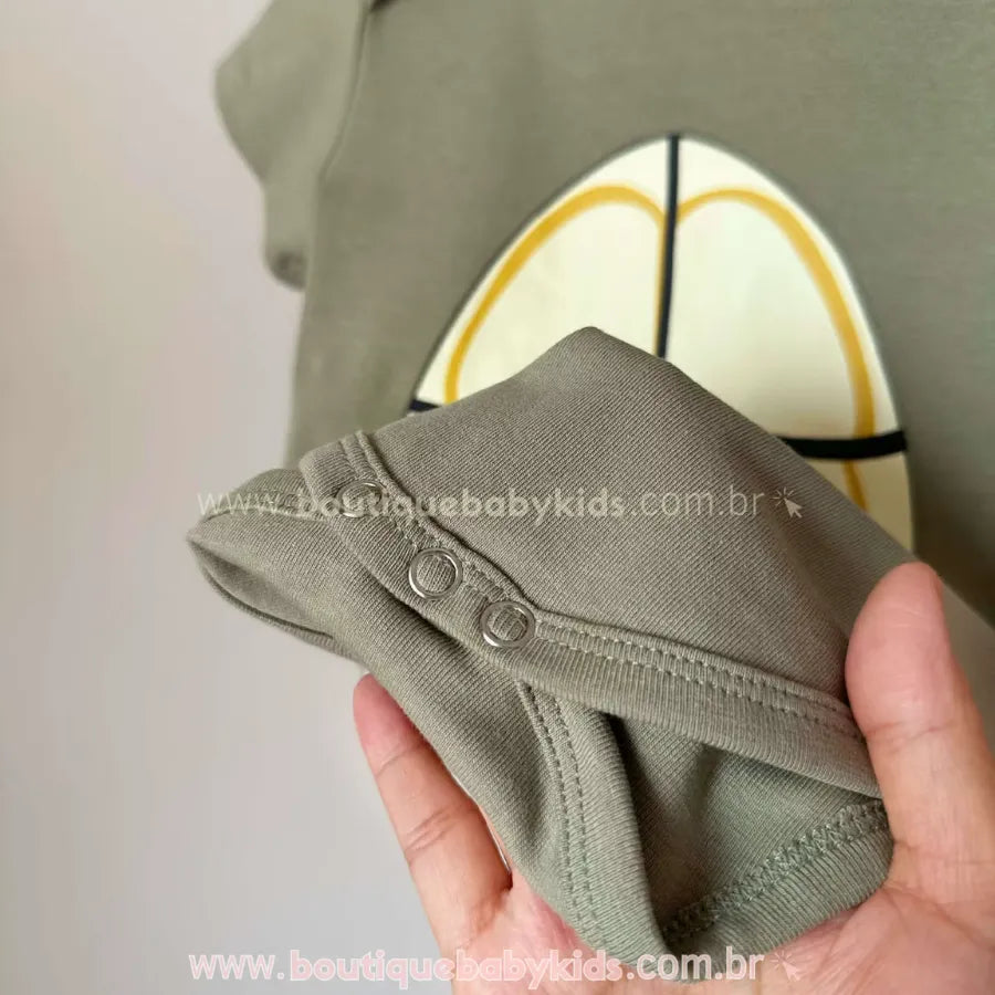 Detalhe do fechamento inferior do body com botões de pressão de metal, facilitando a troca de fraldas durante o uso da fantasia.