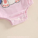 Parte inferior do body bebê jardineira rosa, destacando os botões de pressão para facilitar a troca de fraldas. 