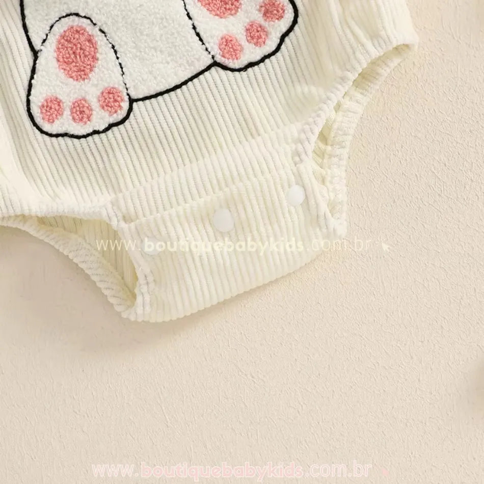 Close da parte inferior do body, mostrando os botões de pressão no entrepernas para facilitar a troca de fraldas. 