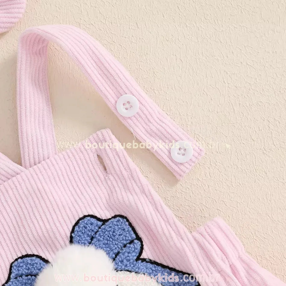 Detalhe das alças ajustáveis do body bebê jardineira rosa, com botões brancos para regulagem. 