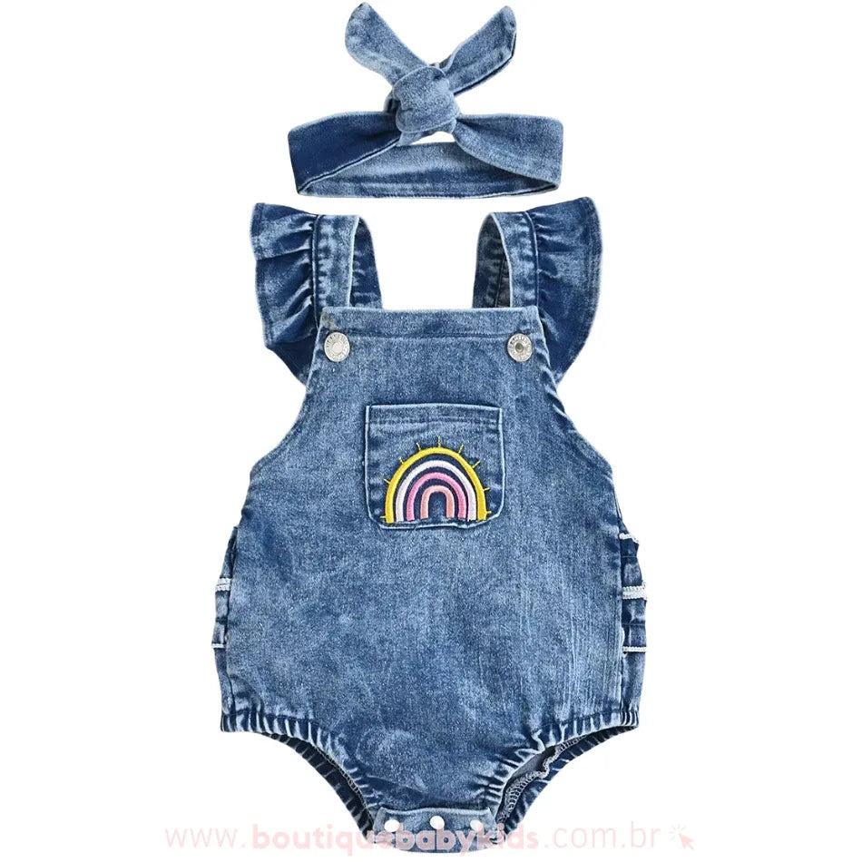 Body bebê jardineira jeans com bordado de arco-íris no bolso frontal, acompanhado por uma faixa de cabelo combinando.
