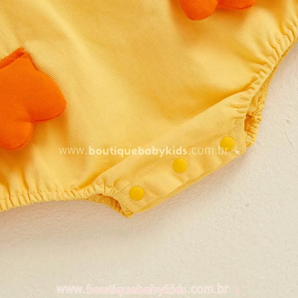 Detalhe dos botões de pressão entre as perninhas do body bebê jardineira patinho, que facilitam a troca de fraldas – Boutique Baby Kids.