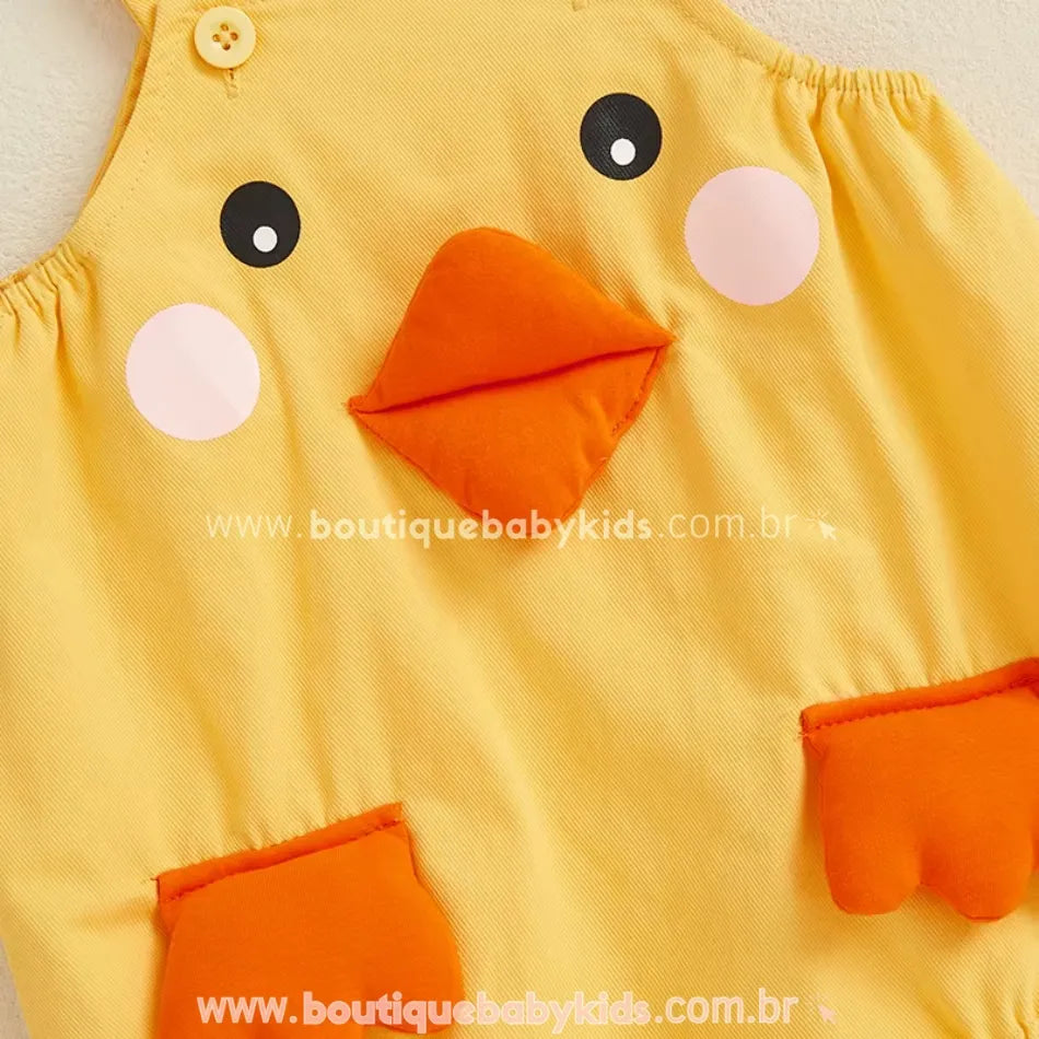 Close do rostinho do patinho no body amarelo com bico em alto relevo e bolsos laranja em forma de patinhas – Boutique Baby Kids.
