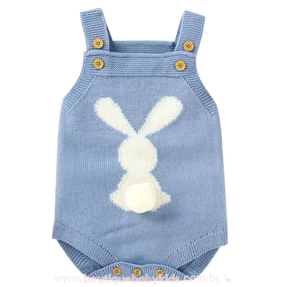 Body bebê jardineira de tricot na cor azul, com alças ajustáveis de botões de madeira e estampa de coelhinho branco nas costas, com um pompom fofo como rabinho. 