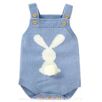 Body bebê jardineira de tricot na cor azul, com alças ajustáveis de botões de madeira e estampa de coelhinho branco nas costas, com um pompom fofo como rabinho. 
