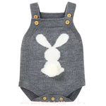 Body bebê jardineira de tricot na cor cinza escuro, com estampa de coelhinho branco e um pompom fofo na parte traseira. 