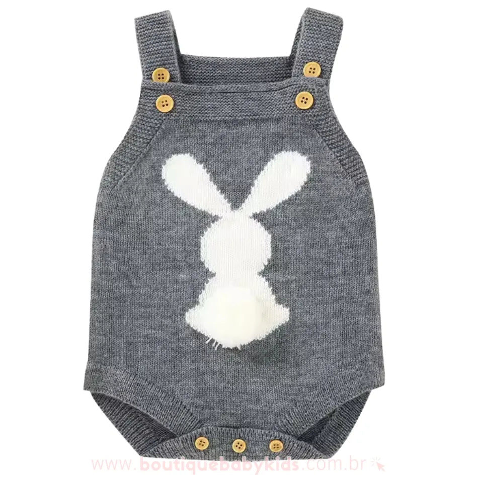 Body bebê jardineira de tricot na cor cinza escuro, com estampa de coelhinho branco e um pompom fofo na parte traseira. 