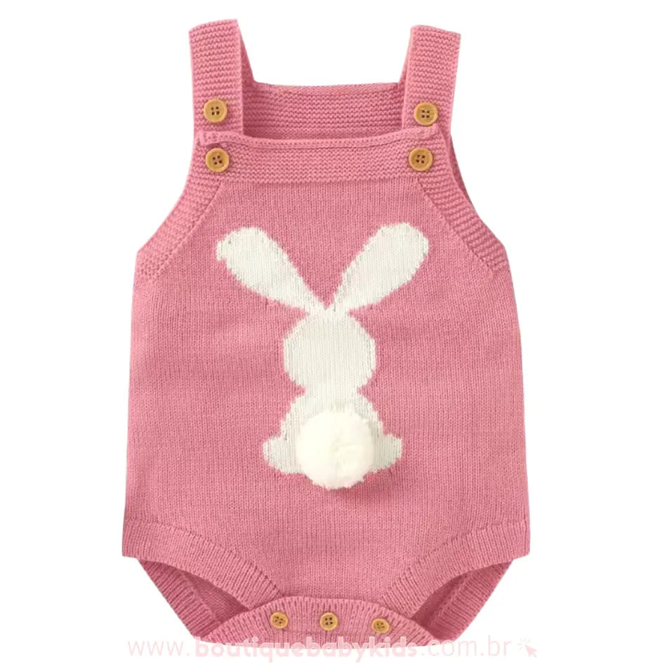 Body bebê jardineira de tricot na cor rosa, com alças ajustáveis e estampa de coelhinho branco nas costas, com um rabinho de pompom macio. 