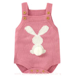 Body bebê jardineira de tricot na cor rosa, com alças ajustáveis e estampa de coelhinho branco nas costas, com um rabinho de pompom macio. 