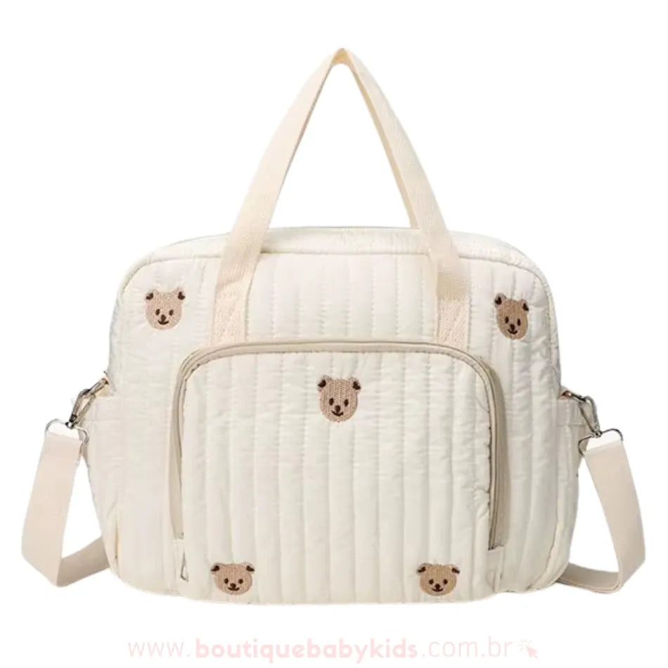 Bolsa Maternidade Ursinho Aconchego vista de frente, exibindo o bolso externo de zíper para organização extra.
