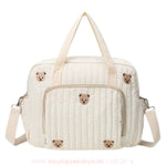 Bolsa Maternidade Ursinho Aconchego vista de frente, exibindo o bolso externo de zíper para organização extra.