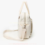 Vista lateral da Bolsa Maternidade Ursinho Aconchego, destacando a alça transversal removível e o tecido acolchoado com detalhes sutis.