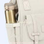 Bolso lateral com suporte elástico, acomodando uma garrafa térmica.