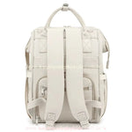 Parte traseira da bolsa mochila maternidade elegance na cor bege, evidenciando as alças ajustáveis e o compartimento com zíper.