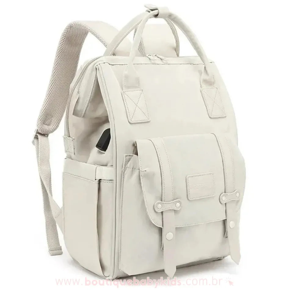 Mochila maternidade Elegance na cor bege, design sofisticado com alças ajustáveis, bolso frontal com fecho duplo e diversos compartimentos laterais.