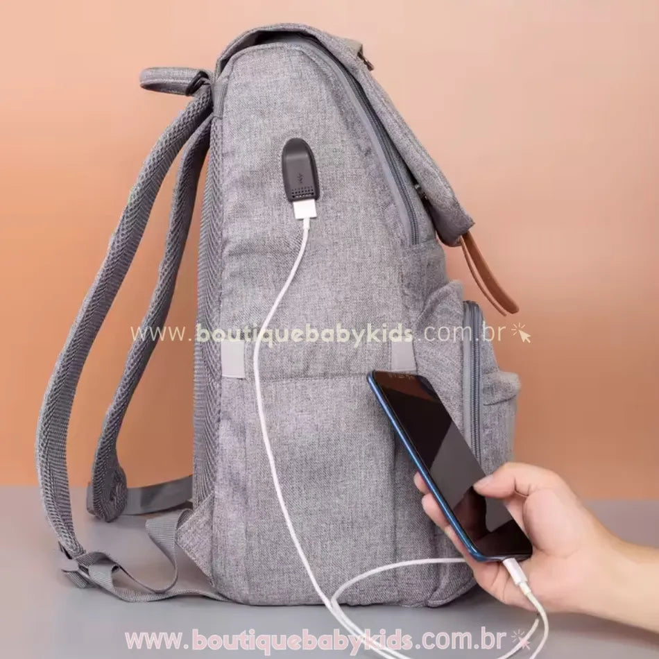 Porta USB embutido na lateral da mochila maternidade Insular Travel, permitindo o carregamento de dispositivos móveis de forma prática e segura.