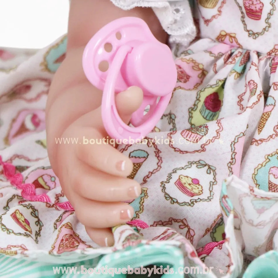 Detalhe da mão da Boneca Bebê Reborn Maria segurando chupeta magnética rosa, com unhas pintadas à mão.