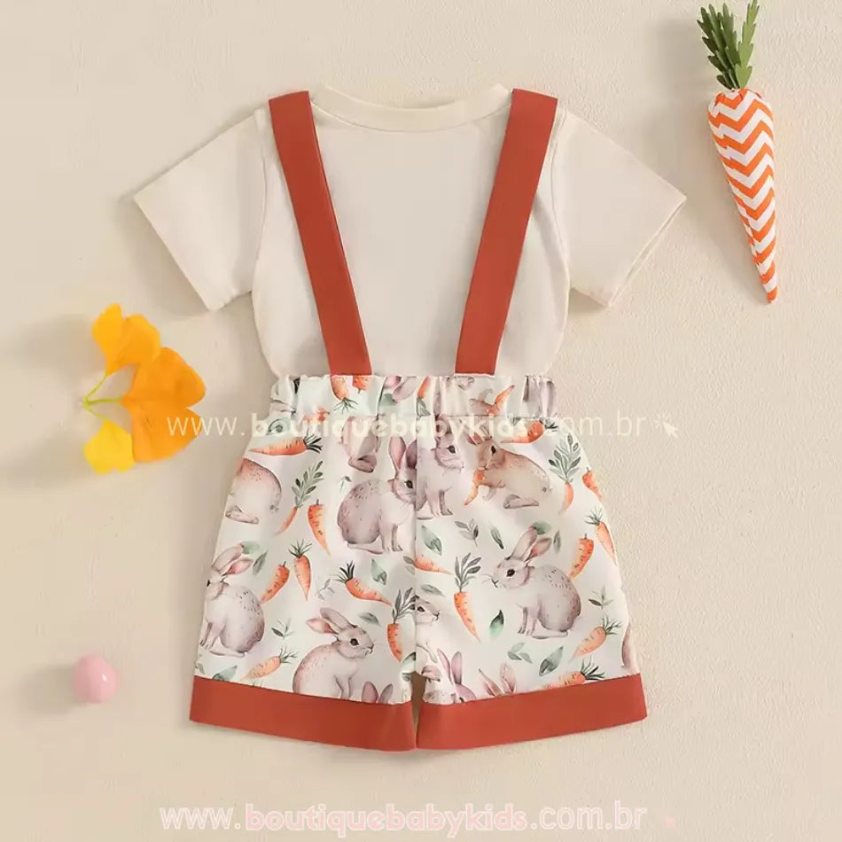 Conjunto infantil de Páscoa visto por trás, com camiseta bege e short estampado de coelhinhos e cenouras. Suspensórios largos fixados por botões.