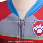 Close-up do zíper frontal da jaqueta do conjunto infantil temático Ryder Patrulha Canina, evidenciando o acabamento e a estampa do emblema da Patrulha Canina no peito.