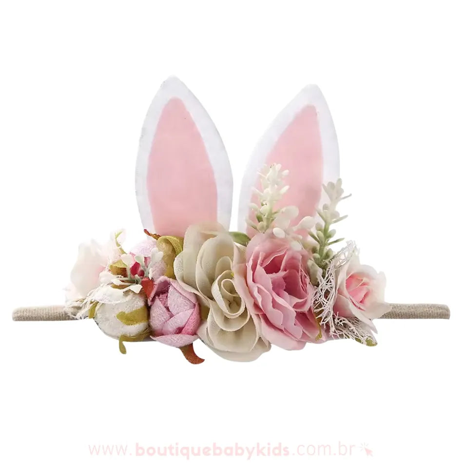 Faixa decorada com flores românticas em tons pastéis e orelhinhas de coelho em tecido branco e rosa, um acessório perfeito para ocasiões festivas.