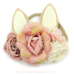 Faixa com orelhas de coelho bege e detalhes florais em tons terrosos e pastéis, trazendo um toque natural e sofisticado ao acessório.