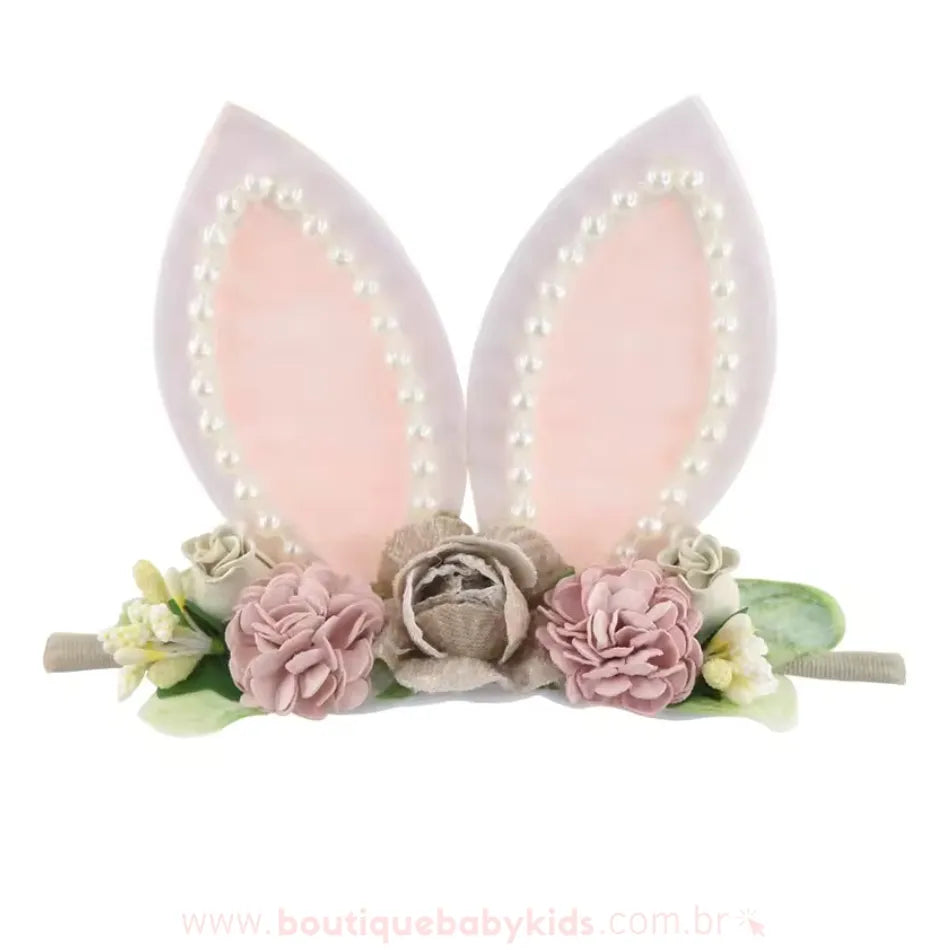 Faixa temática de Páscoa com orelhas de coelho decoradas com pérolas e flores em tons suaves de bege, rosa e verde, criando um visual delicado e encantador.