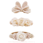 Kit com três faixas florais em tom bege, incluindo uma faixa com orelhinhas de coelho e laço de cetim perolado, uma faixa com flores grandes de cetim branco e outra com flores menores em um arranjo delicado.