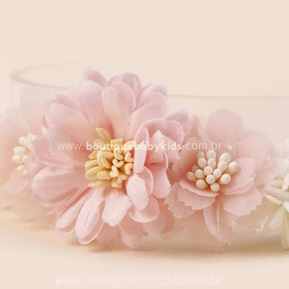 Detalhe de faixa floral rosa com flores em camadas e apliques delicados no centro, trazendo um visual romântico e delicado.