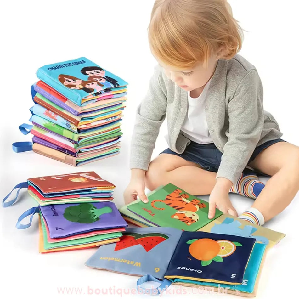 Criança pequena sentada no chão explorando um livro sensorial ilustrado com animais. Ao redor, há uma pilha de livros coloridos com diferentes temas, incentivando a interação e a aprendizagem.